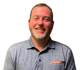 Man with beard in SERVPRO collared shirt against white background