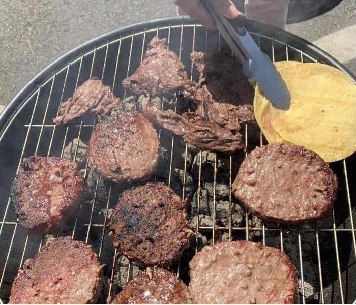 burgers cooking on a grill at the Labor Day barbecue